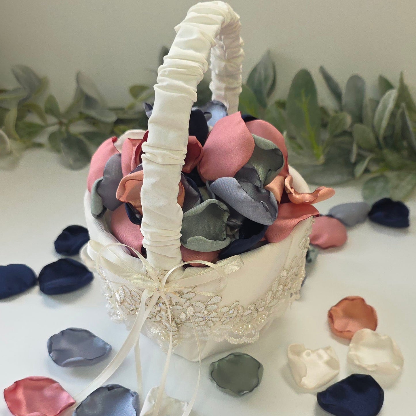 a mix of Dusty Blue, Navy, Dusty Rose, champagne rose pink, dusty sage rose petals in a ivory flower girl basket. Perfect for flower girl tossing, aisle decor, inspo for wedding decor, tablescape scatter or backdrop accents. A color palette for a future bride planning a wedding ceremony or bridal shower brunch event.