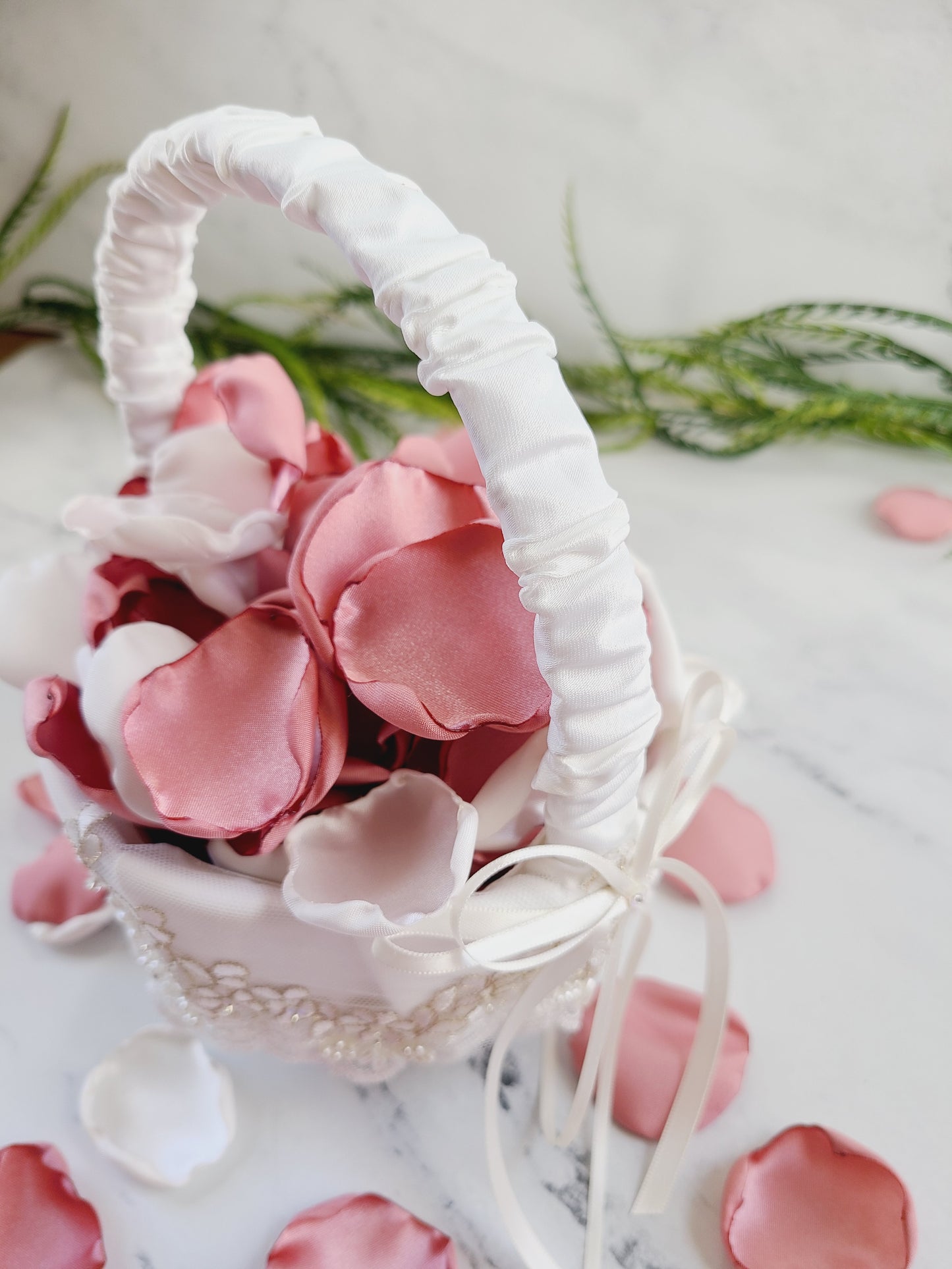 Ivory flower girl basket filled with Mauve, pink rose petals. Table confetti