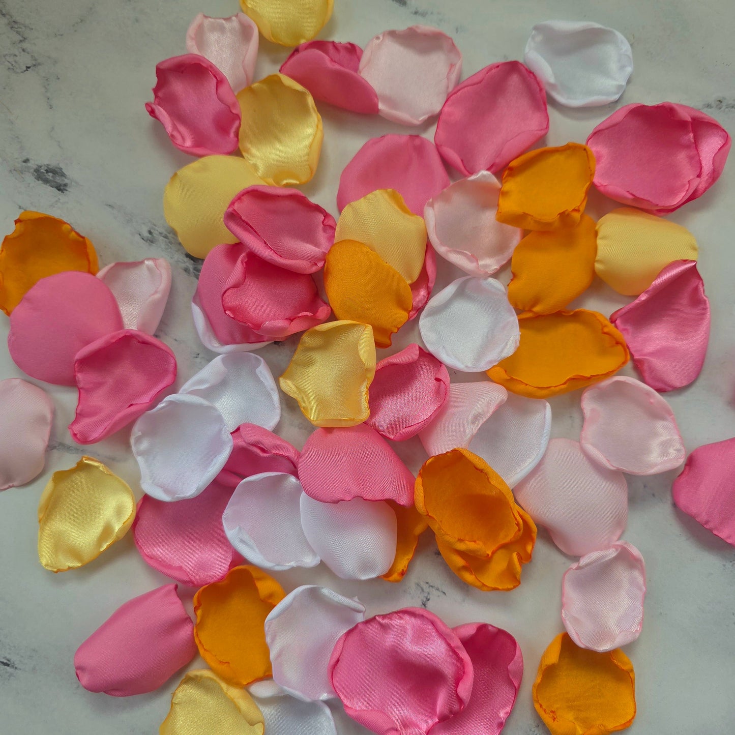 Orange, pink, white and yellow rose petals showcased on tabletop. perfect for wedding aisle decor, flower girl baskets, tablescapes, memory table accents. Sunset wedding decor , enchance your whimsical, boho, rustic western wedding ideas