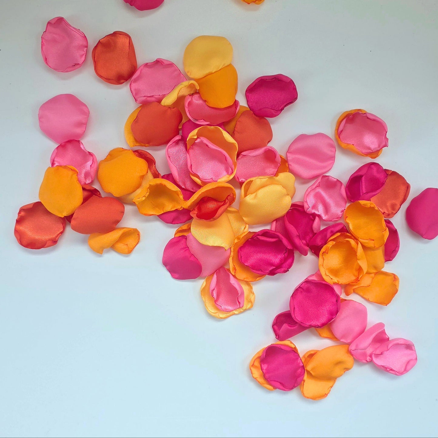 A mix of pink, fuchsia, yellow, tangerine and orange rose petals. For flower girl toss, aisle decor, reception tablescapes confetti scatter. for future brides using a sunset wedding color palette to plan a bridal shower event or wedding ceremony.