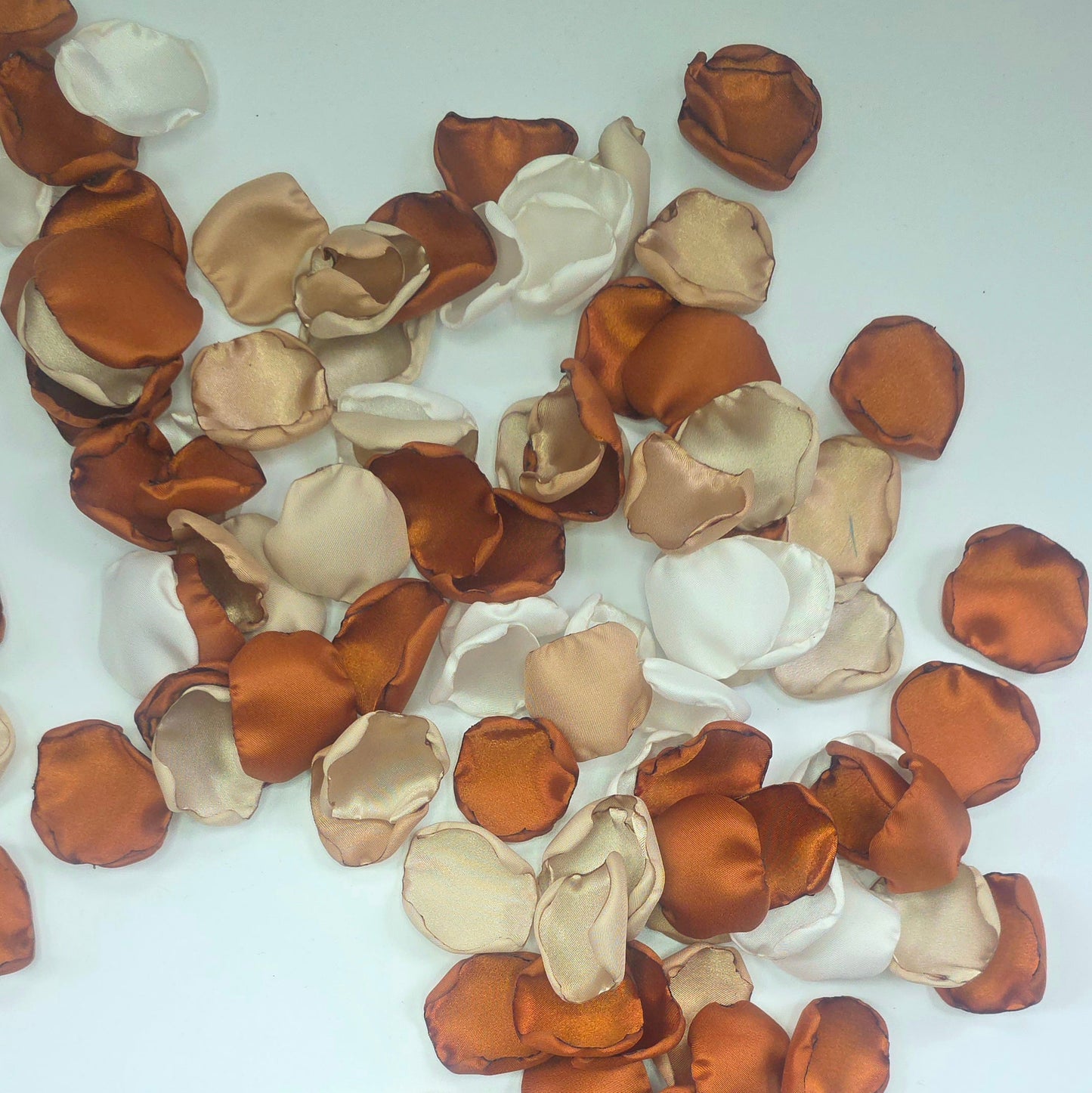 A mix of rose petals featuring an Auburn, terracotta, burnt orange color palette that includes beige, taupe and off white petals. Perfect for flower girl baskets and tossing, aisle decor, flatlays, reception tablescape decorations, table scatter and confetti toss. Wedding decor ideas for the future bride planning a fall wedding ceremony or a boho western bridal shower event.