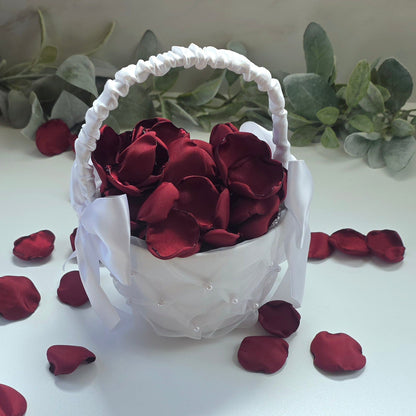 Burgundy rose petals in white flower girl basket for tossing, aisle decor, classic fall wedding decor. Ideas for future brides planning an elegant wedding ceremony or bridal shower event.