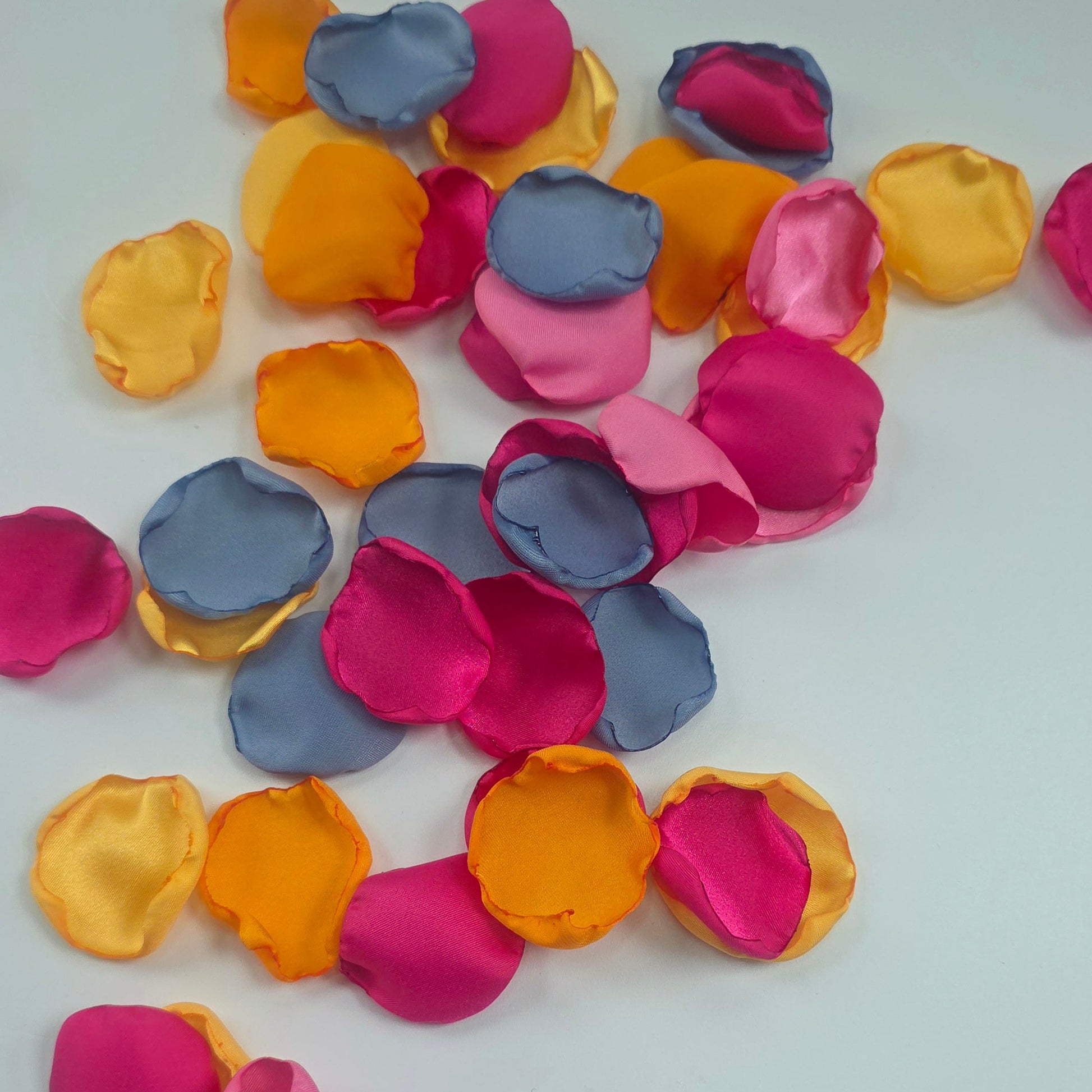 A mix of Tangerine Mango Orange, Fuchsia, Candy pink, sunset orange and dusty blue rose petals. Perfect for aisle decor, flower girl tossing. table scatter, backdrop accents or photo flatlays ideas. A golden hour, topical, and sunset vibes for a future bride planning a wedding ceremony or bridal shower event. A bold colorful, modern color palette inspiration and wedding decor ideas. 
