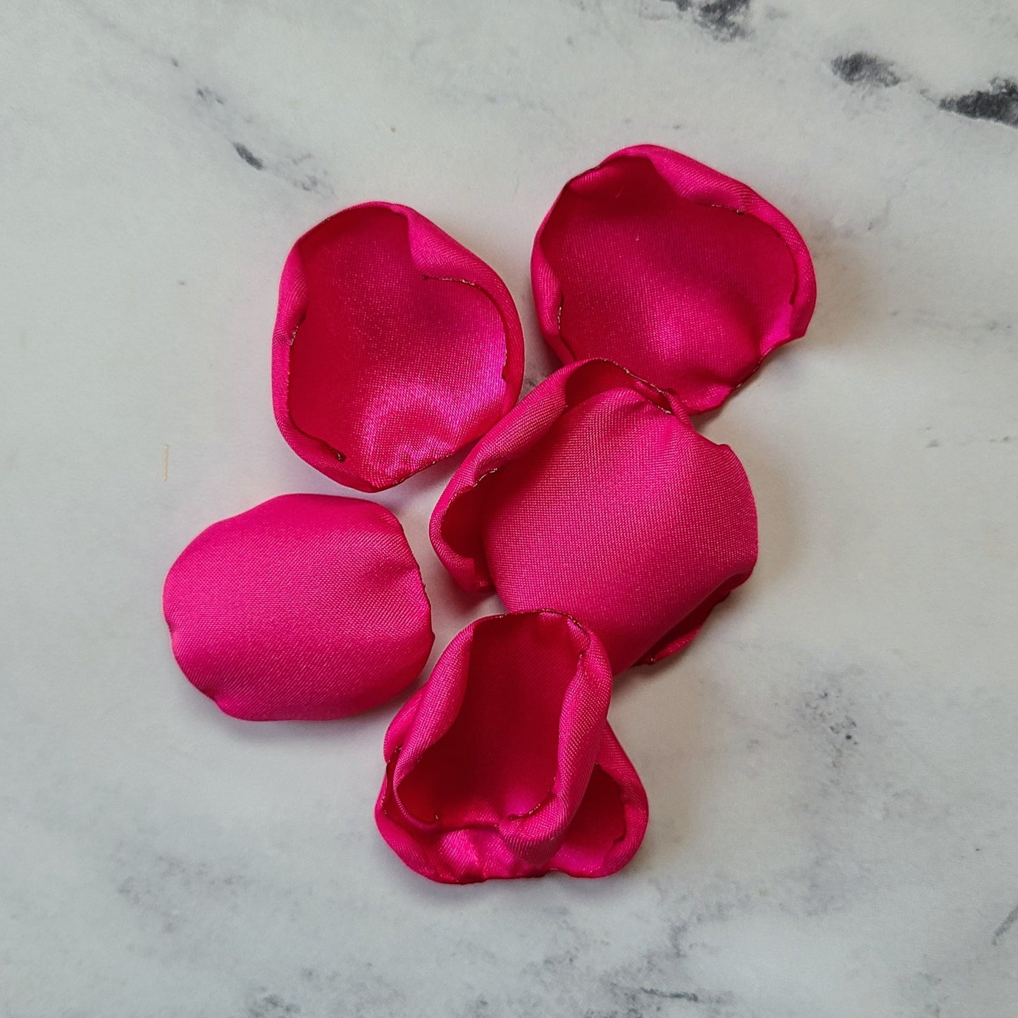 Fuchsia pink rose petals showcased on tabletop. Perfect for tablecapes decor, flower girl toss, wedding aisle decor, confetti scatter, ceremony backdrop props