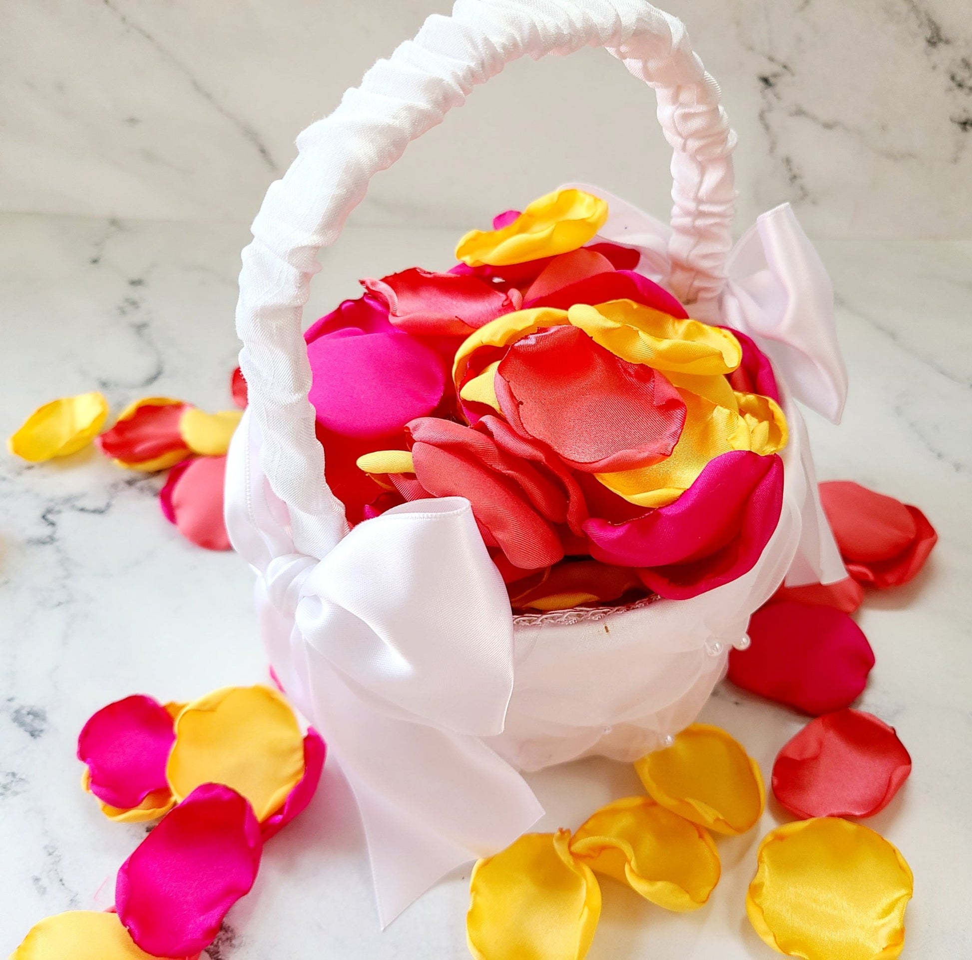 Yellow, Coral and Hot Pink rose petals in White flower girl basket. 