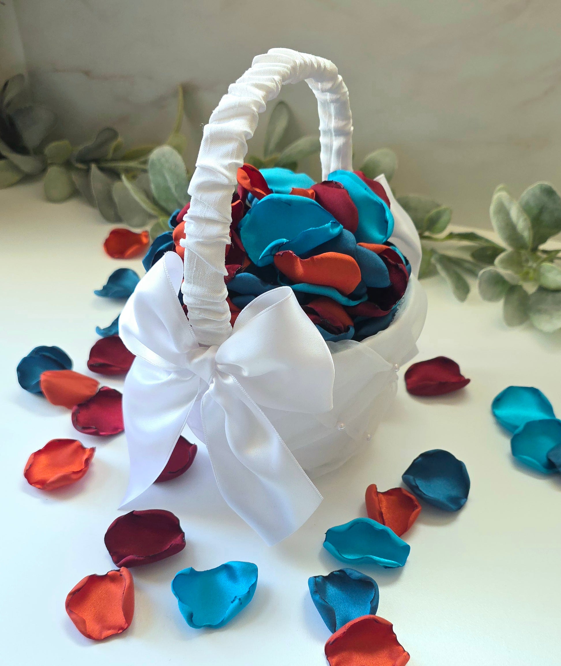 Teal, Burgundy, Burnt Orange & beige rose petals in white flower girl basket for flower girl toss, baskets, table scatter, flatlays or wedding aisle decor. Perfect for future brides planning a fall jewel toned wedding, or a She's tying the Knot bridal shower event. 