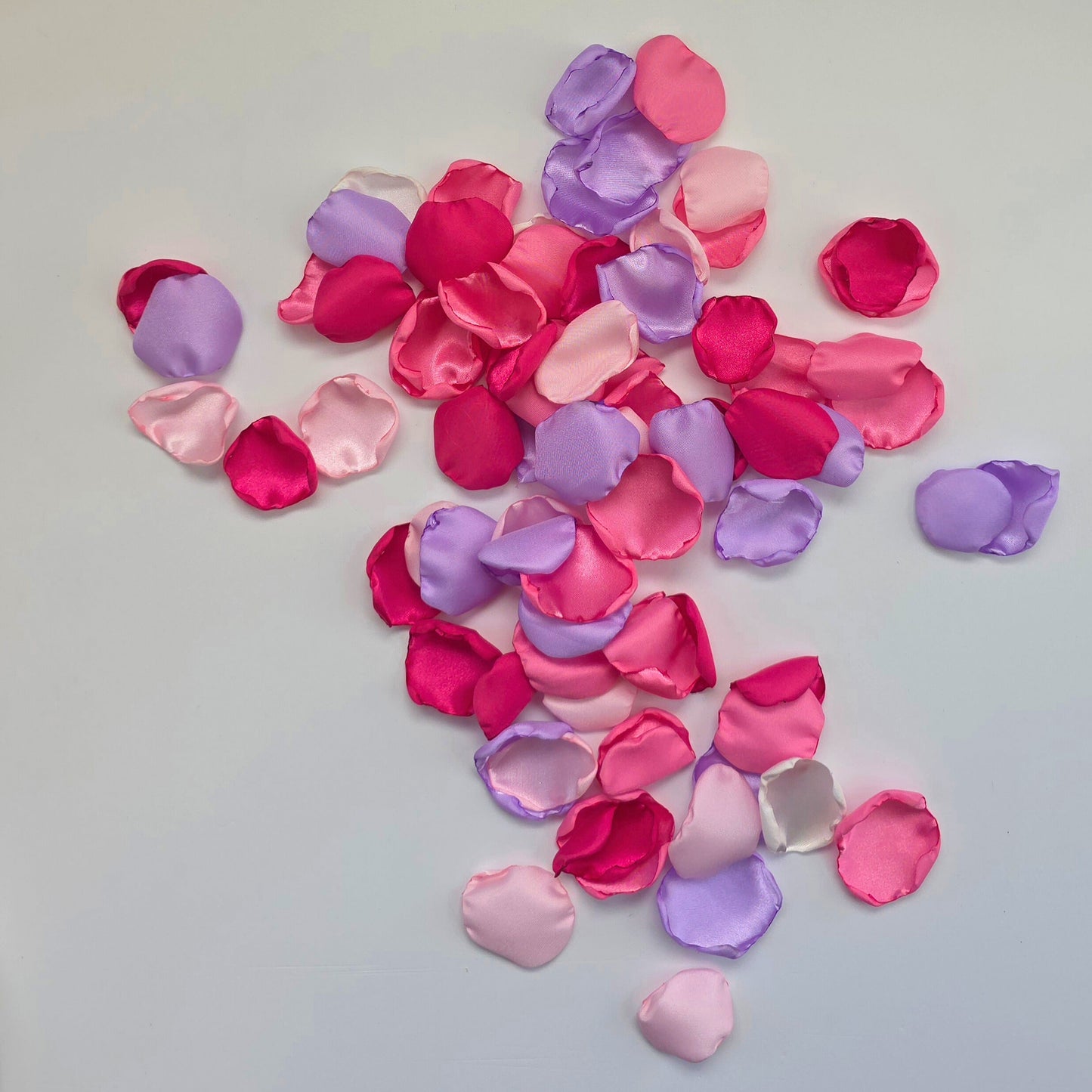Lilac Purple, pinks and fuchsia rose petals on table. Used for flower girl toss, future bride ideas, confetti scatter on reception tables, baskets, wedding aisle decor
 