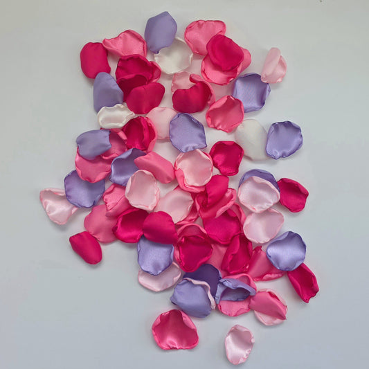Lilac Purple, pinks and fuchsia rose petals on table. Used for flower girl toss, future bride ideas, confetti scatter on reception tables, baskets, wedding aisle decor