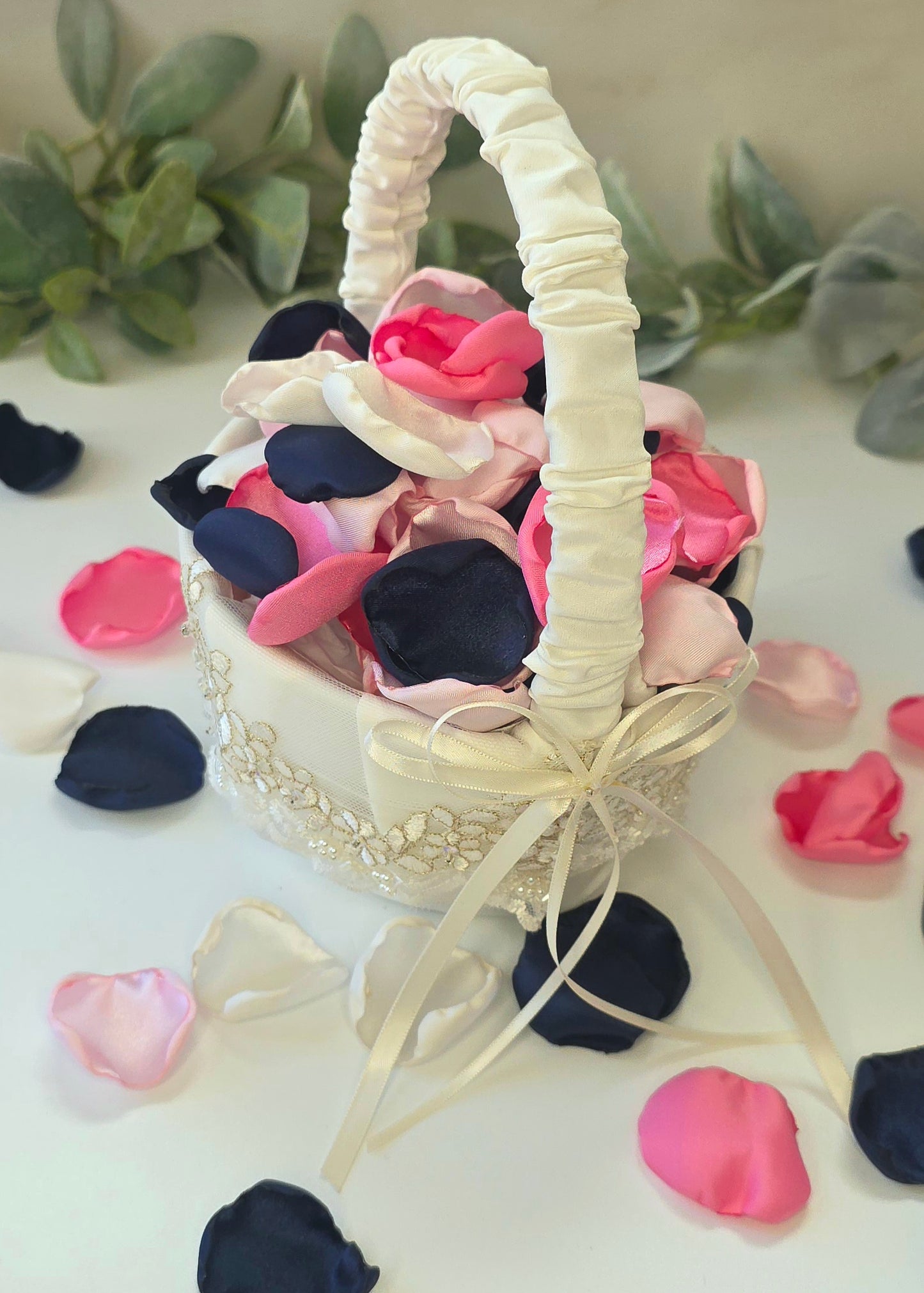 A mix of Candy pink, blush, ivory and navy blue rose petals in ivory basket for flower girl toss, tablescape table scatter, and aisle decor. For future brides planning a romantic, classic wedding ceremony or sping, whimsical bridal shower event.