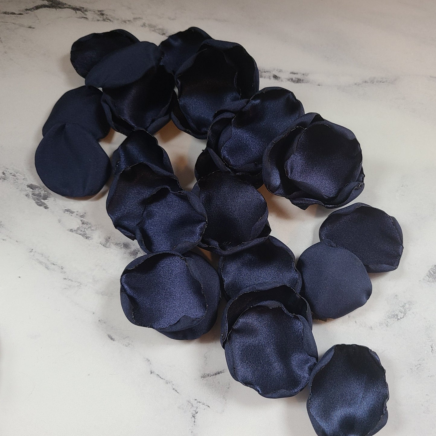 Navy blue rose petals on a wedding reception table for decor
