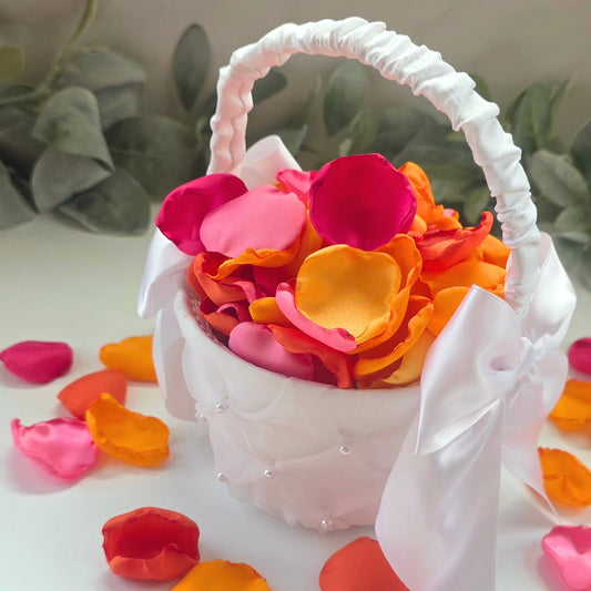 A mix of pink, fuchsia, yellow, tangerine and orange rose petals in a white flower girl basket. For flower girl toss, aisle decor, reception tablescapes confetti scatter. for future brides using a sunset wedding color palette to plan a bridal shower event or wedding ceremony.