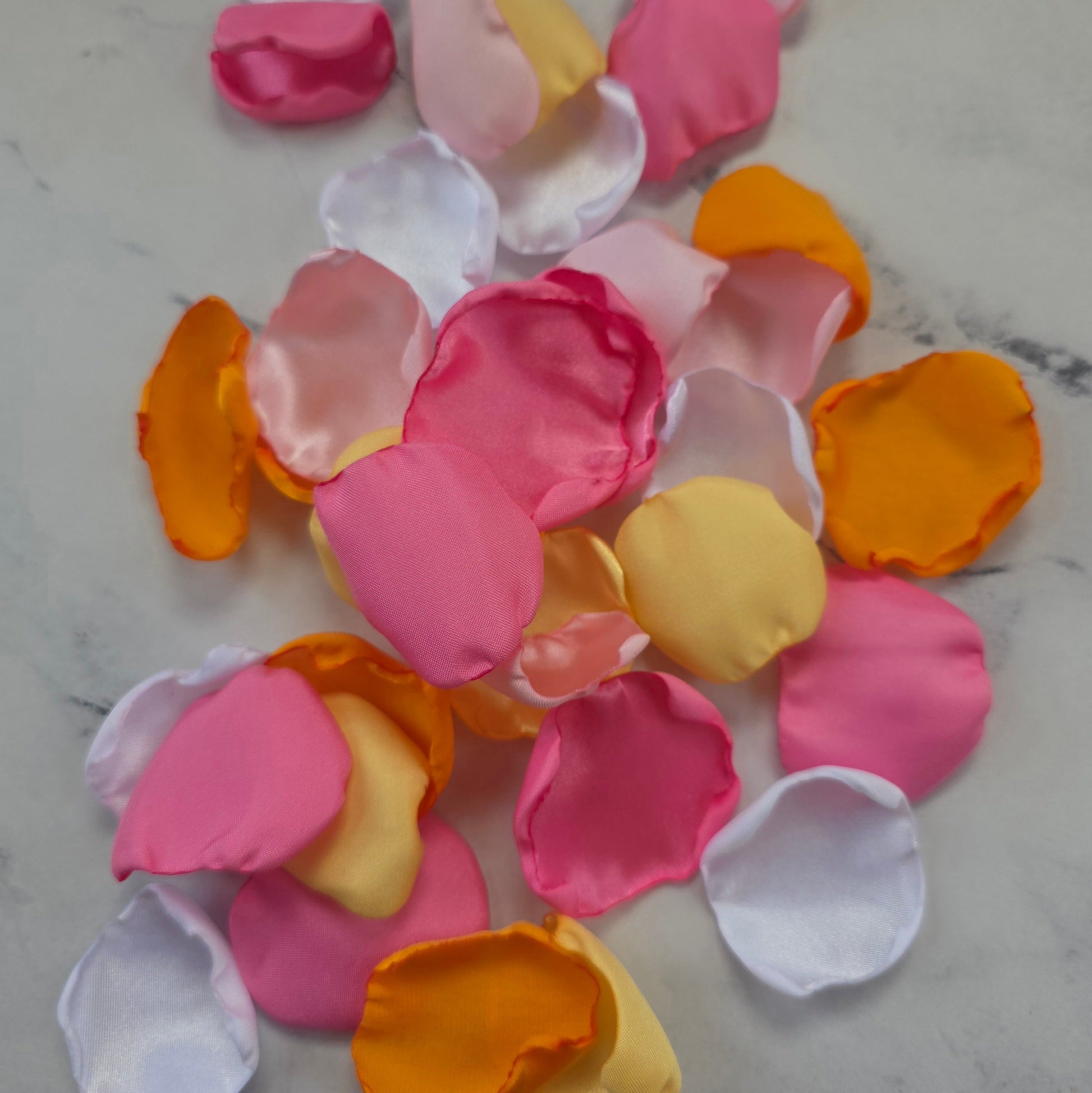 Orange, pink, white and yellow rose petals showcased on tabletop. perfect for wedding aisle decor, flower girl baskets, tablescapes, memory table accents. Sunset wedding decor , enhance your whimsical, boho, rustic western wedding ideas 