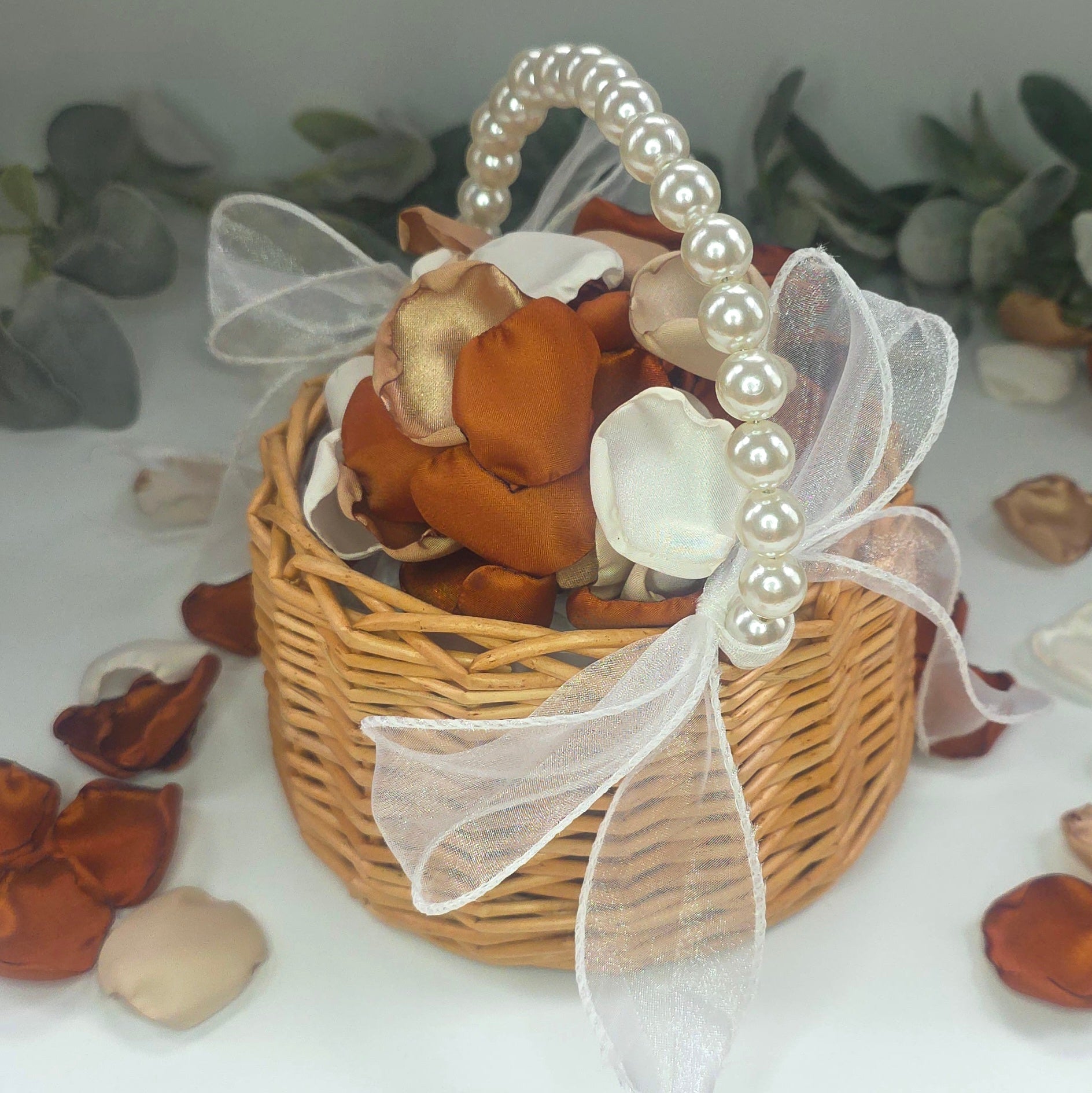 A rustic flower girl basket with A mix of rose petals featuring an Auburn, terracotta, burnt orange color palette that includes beige, taupe and off white petals. Perfect for flower girl baskets and tossing, aisle decor, flatlays, reception tablescape decorations, table scatter and confetti toss. Ideas for the future bride planning a fall wedding ceremony or a boho western bridal shower event.