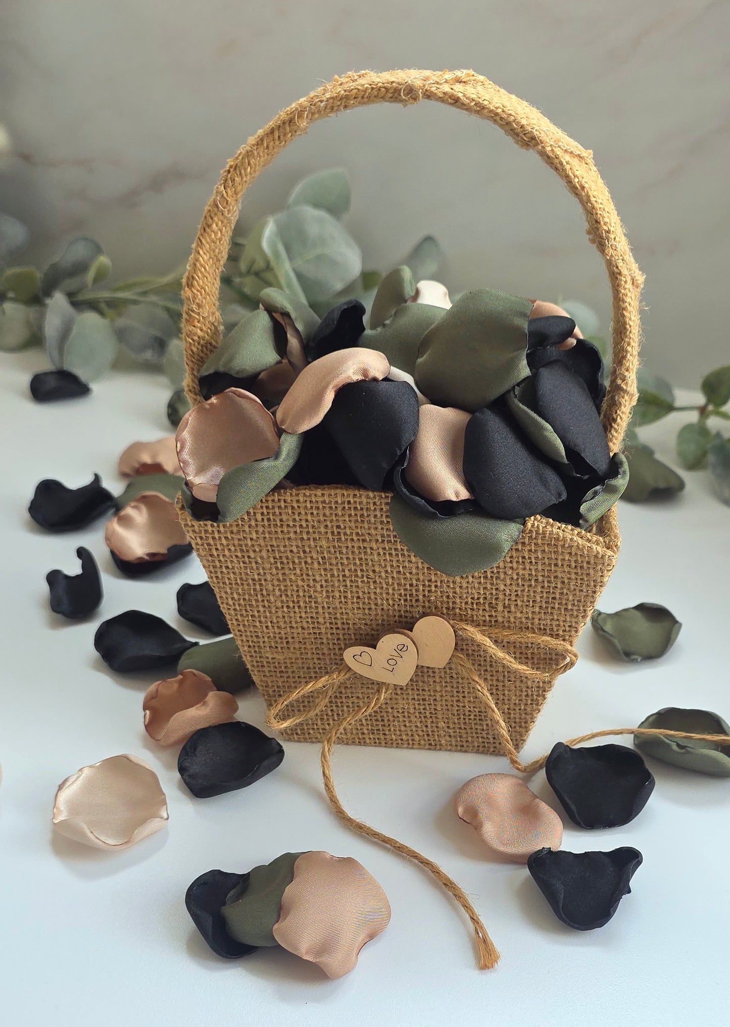 A mix of olive green, tan, beige and black rose petals in a rustic burlap flower girlbasket. . Perfect for flower girl tossing, flatlays, table scatter, confetti exit,wedding aisle decor.  For future brides planning a Camouflage wedding or hunting couples shower event.