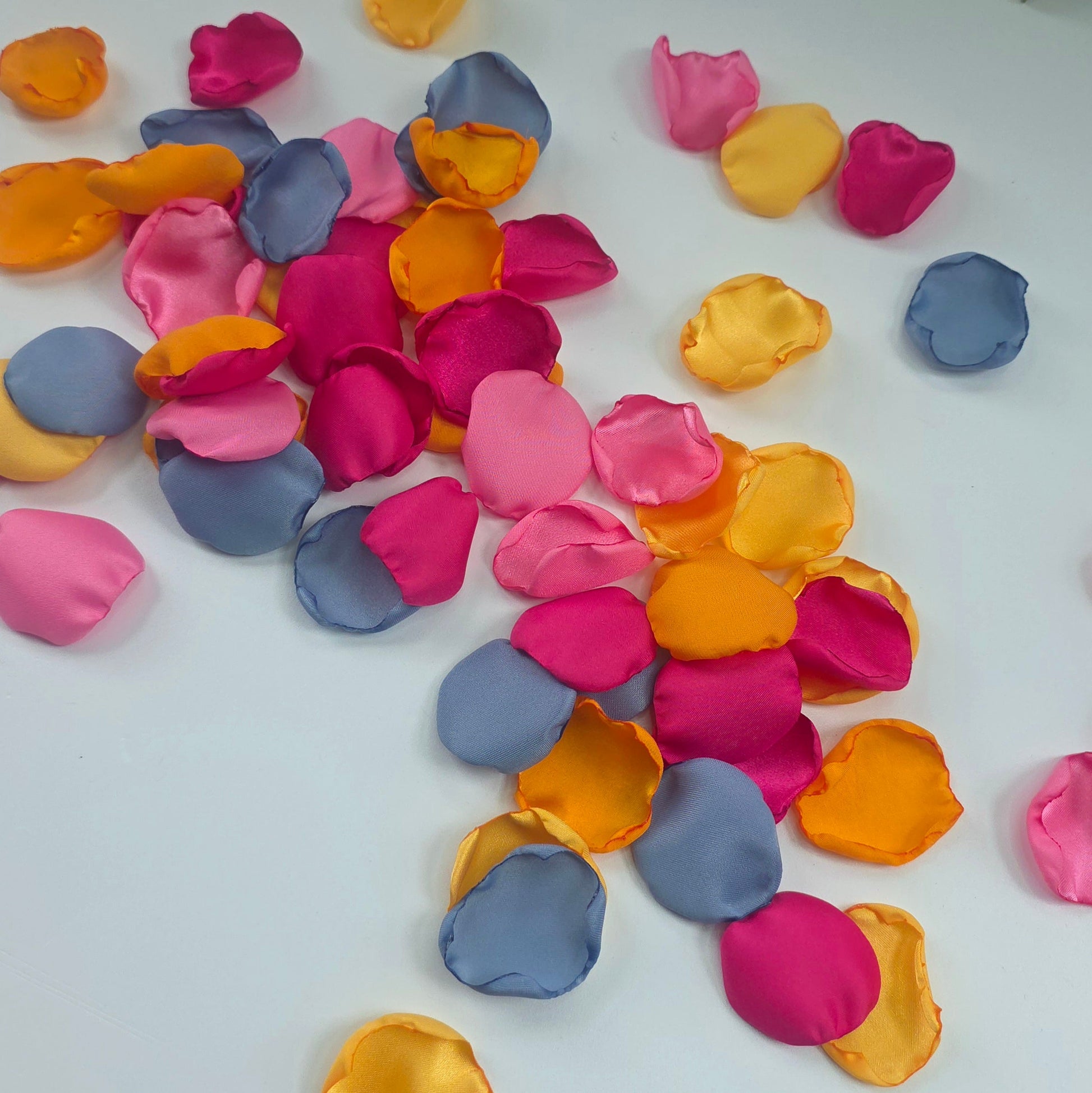 A mix of Tangerine Mango Orange, Fuchsia, Candy pink, sunset orange and dusty blue rose petals. Perfect for aisle decor, flower girl tossing. table scatter, backdrop accents or photo flatlays ideas. A golden hour, topical, and sunset vibes for a future bride planning a wedding ceremony or bridal shower event. A bold colorful, modern color palette inspiration and wedding decor ideas. 