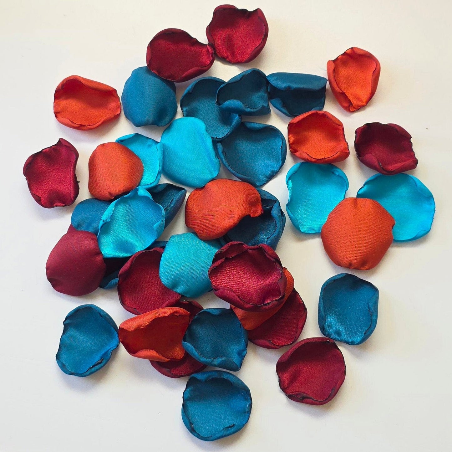 A mix of  burgundy, burnt orange, dark and light teal rose petals for flower girl tossing, baskets, aisle decor or tablescape  confetti scatter. Ideas for future brides planning a jewel toned wedding ceremony or fall bridal shower event.
