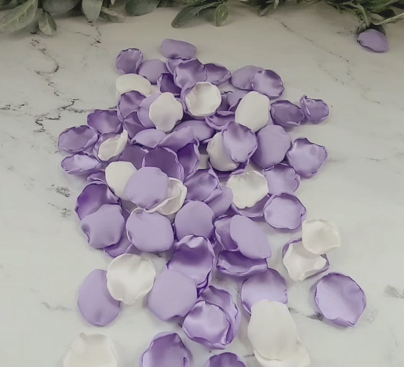 Load video: Lavender Purple &amp; Ivory rose petals gently tossed by the flower girl on a wedding table used as confetti or wedding decor.