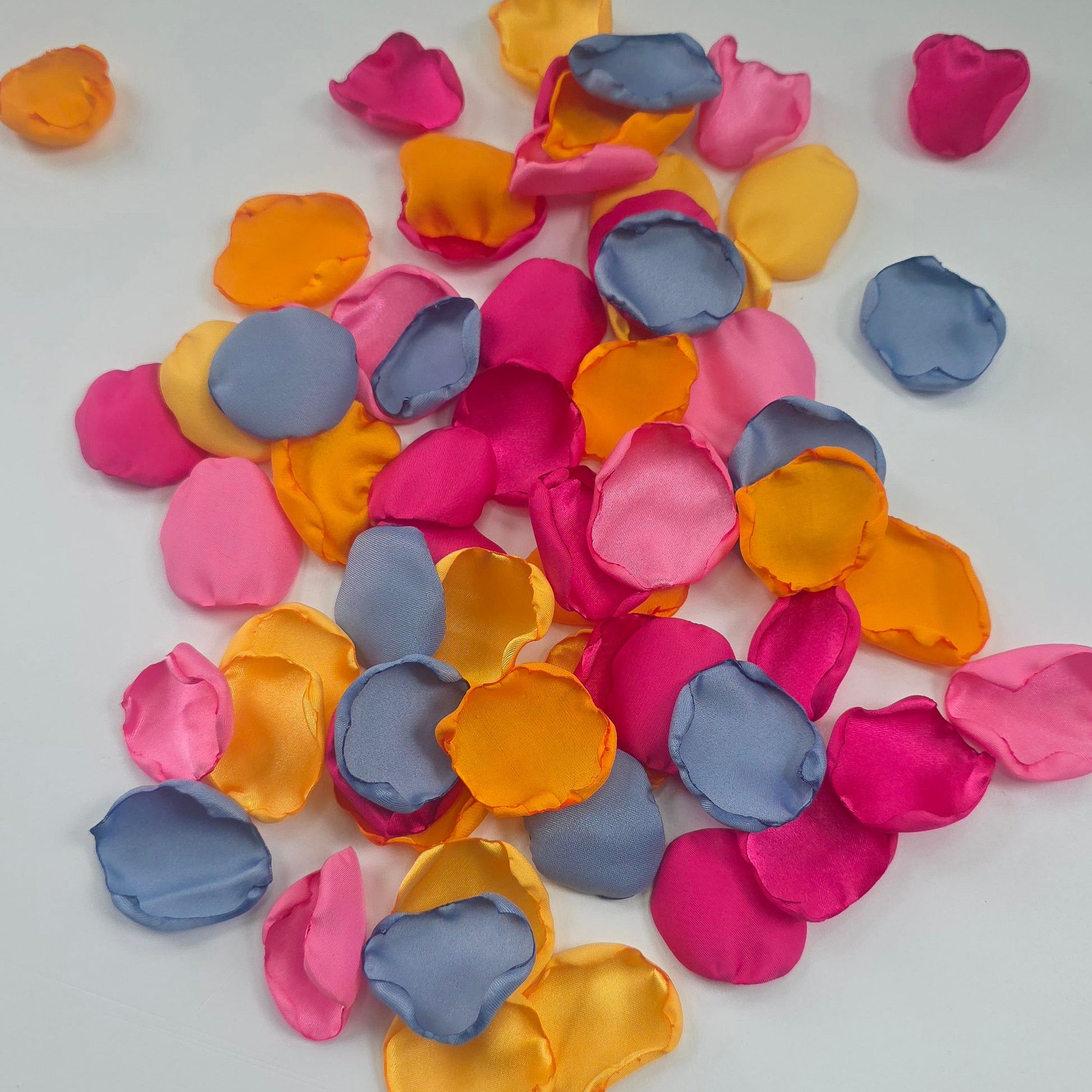 A mix of Tangerine Mango Orange, Fuchsia, Candy pink, sunset orange and dusty blue rose petals. Perfect for aisle decor, flower girl tossing. table scatter, backdrop accents or photo flatlays ideas. A golden hour, topical, and sunset vibes for a future bride planning a wedding ceremony or bridal shower event. A bold colorful, modern color palette inspiration and wedding decor ideas. 